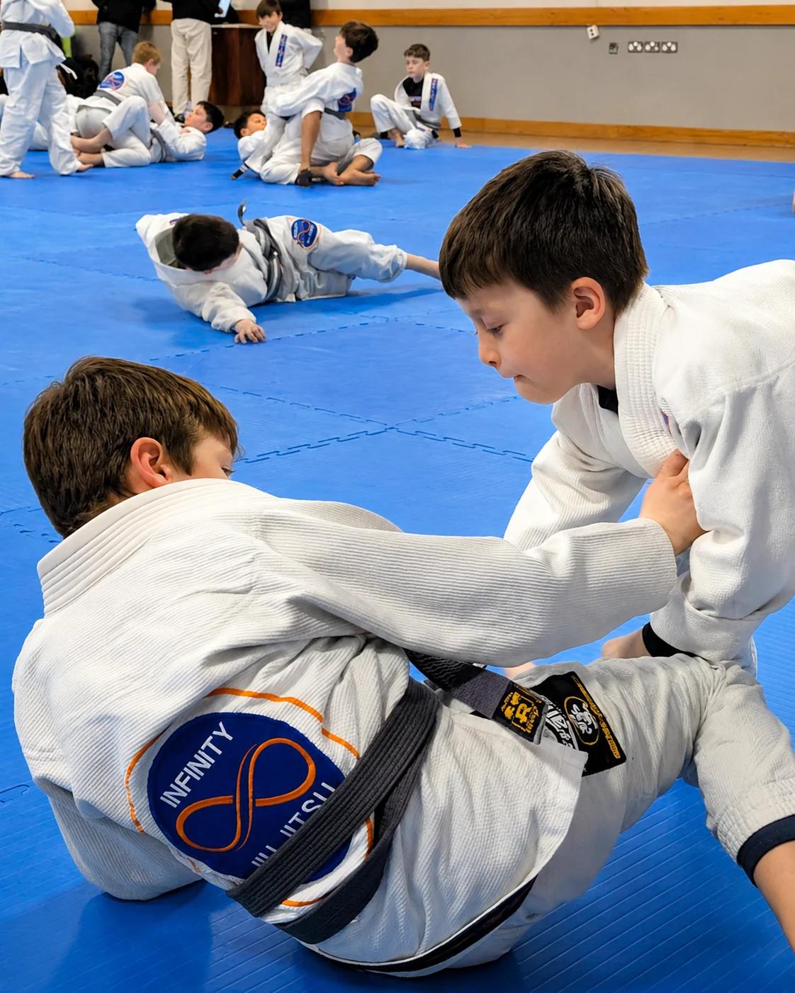 Little Champions students in white gi uniforms with their coach at Infinity Jiu-Jitsu in Portmarnock