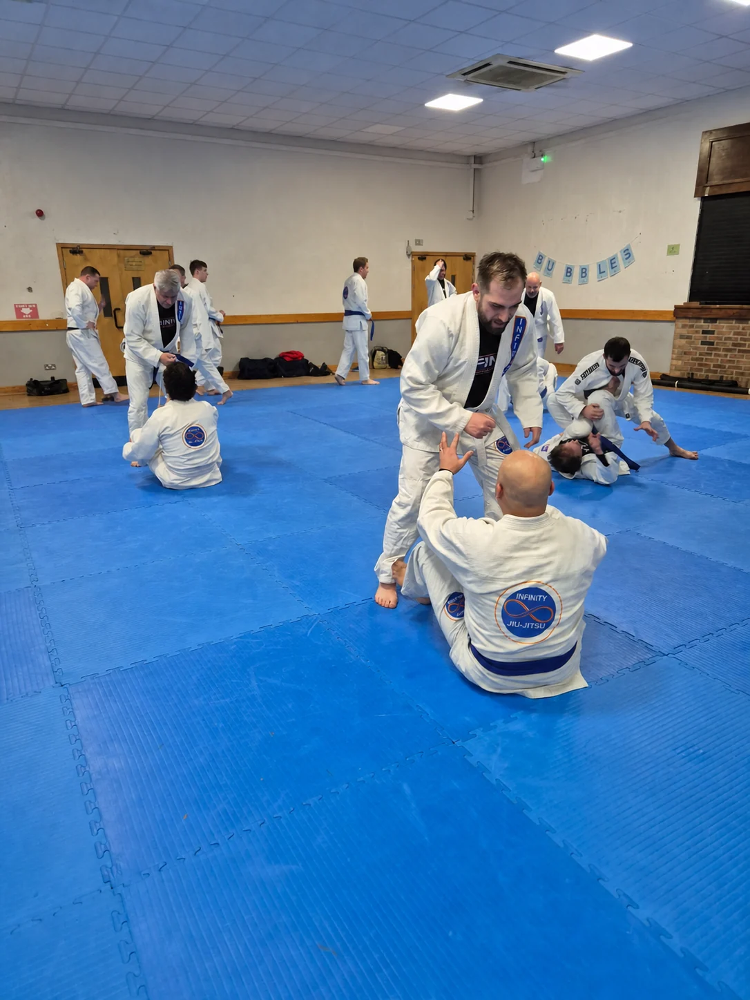 Infinity Jiu-Jitsu students training together during a regular class